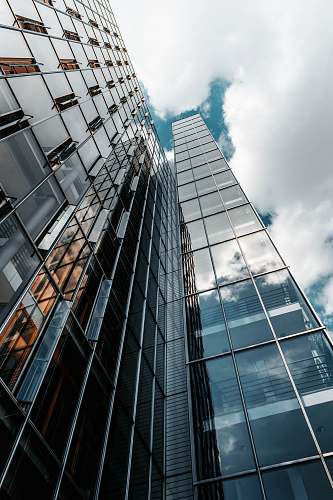 office building low angle photography of glass building under cloudy sky urban